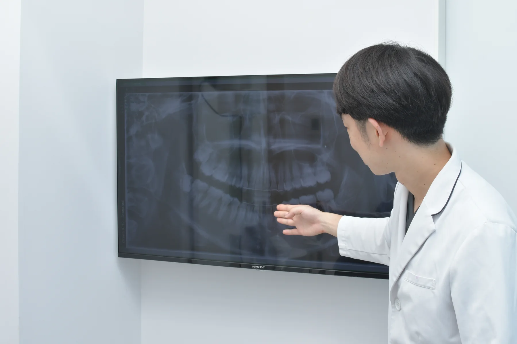 豊洲の歯科で原因から考える根本治療を説明する歯科医師